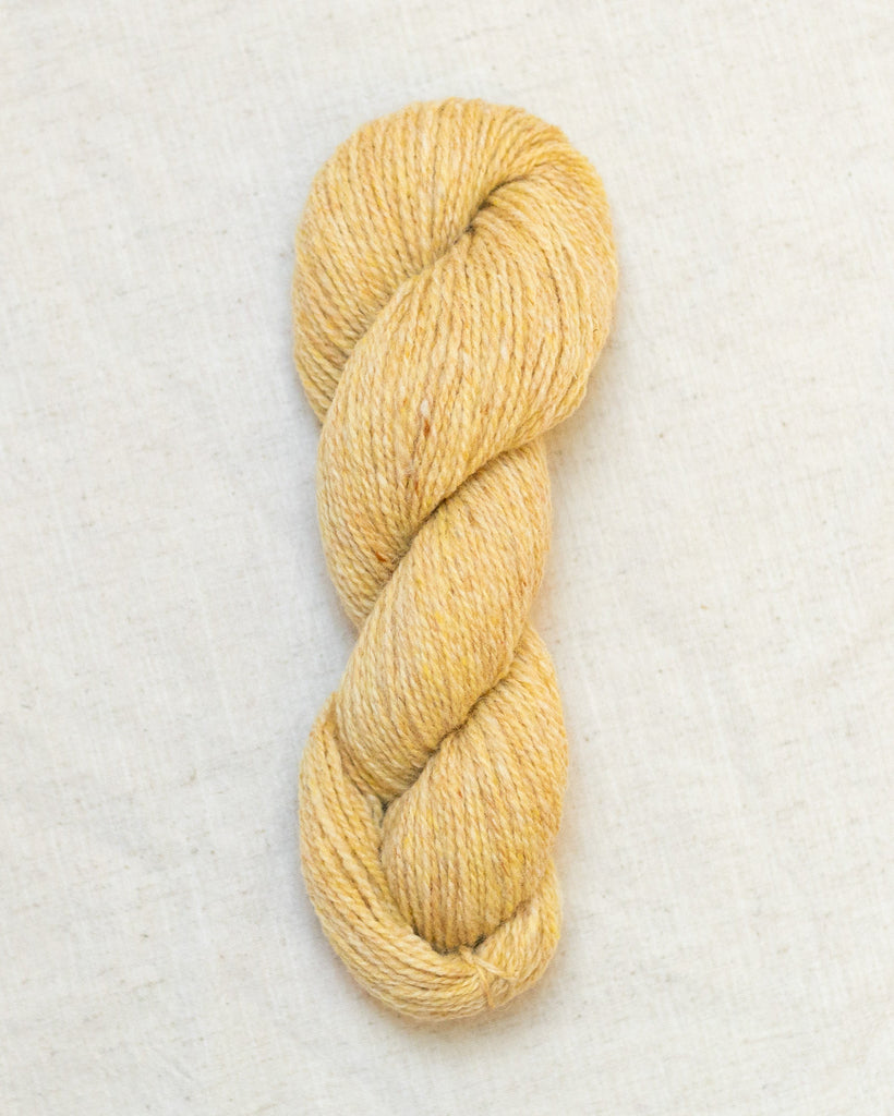 Skein of yellow yarn on a white background